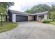 Charming home featuring stone accents, dark grey garage door, and a well-maintained front yard at 910 Van Dr, Auburndale, FL 33823