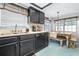 Functional kitchen featuring black cabinets, a modern faucet, and an adjacent dining area at 910 Van Dr, Auburndale, FL 33823