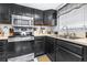 Well-lit kitchen featuring stainless appliances, black cabinets, and a dining area at 910 Van Dr, Auburndale, FL 33823