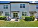Townhome backyard with a concrete patio, grill, lawn, and trimmed bushes for outdoor living at 943 Grandin St, Davenport, FL 33837