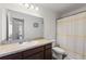 Bright bathroom features a vanity with a large mirror and a shower with a white and yellow striped curtain at 943 Grandin St, Davenport, FL 33837