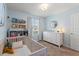 Charming Bedroom with a crib, dresser, decorative shelves, and a soothing light blue color scheme at 943 Grandin St, Davenport, FL 33837