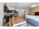 Open-concept living space flows from the kitchen with stainless appliances to the living room with a cozy gray couch at 943 Grandin St, Davenport, FL 33837