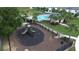 Aerial view of a community playground and swimming pool in a fenced area with palm trees at 943 Grandin St, Davenport, FL 33837