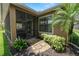 Exterior view showcasing a screened-in patio, well-manicured landscaping, and a charming palm tree at 961 Christina Chase Dr, Lakeland, FL 33813