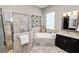 Gorgeous main bath featuring a tub, shower, glass block window, and dark cabinets at 961 Christina Chase Dr, Lakeland, FL 33813
