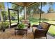 Comfortable screened-in patio featuring brick floors, cozy seating, and views of the lush backyard at 961 Christina Chase Dr, Lakeland, FL 33813