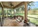 Inviting screened-in patio with brick floors, comfortable seating, and a charming porch swing for relaxing outdoors at 961 Christina Chase Dr, Lakeland, FL 33813