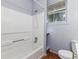 A gray bathroom with wooden floors and a shower at 121 F Sw Ave, Winter Haven, FL 33880