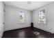 Bedroom featuring two windows, dark wooden floors, and an air conditioning unit at 121 F Sw Ave, Winter Haven, FL 33880
