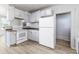 Bright kitchen with white cabinets, laminate countertops and floors, and white appliances at 121 F Sw Ave, Winter Haven, FL 33880