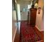 Hallway with antique furniture, brick floors, and classic Persian rug leading to a front door at 1216 W Lake Buckeye Dr, Winter Haven, FL 33881