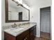 Bathroom with double sinks, granite countertops, dark wood cabinets, and a neutral color palette at 1232 Fairlee St, Lakeland, FL 33813