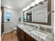 Modern bathroom with double sink vanity, granite countertops, and framed mirror at 1232 Fairlee St, Lakeland, FL 33813