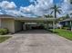 Open carport with storage area and space for parking, plus a view of the well-maintained lawn and landscaping at 1232 Fairlee St, Lakeland, FL 33813