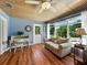 Comfortable living room featuring wood floors, blue walls, a beadboard ceiling, and natural light at 1232 Fairlee St, Lakeland, FL 33813