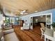 Spacious living room with wood floors, blue walls, multiple seating areas, and a beadboard ceiling at 1232 Fairlee St, Lakeland, FL 33813