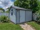 The outdoor storage shed features neutral colors and matches the design of the home, with a window for ventilation at 1232 Fairlee St, Lakeland, FL 33813