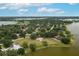 Aerial view of a waterfront home surrounded by lush greenery and a vast lake at 21 Lake Ave, Winter Haven, FL 33880