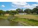 Expansive backyard featuring lush greenery, a tranquil lake view, a wooden dock, and patio furniture at 21 Lake Ave, Winter Haven, FL 33880