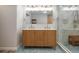 Bathroom featuring double sinks, wood vanity, large mirror and walk-in shower at 21 Lake Ave, Winter Haven, FL 33880