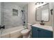Bathroom featuring tub with shower, tile backsplash, and blue vanity at 21 Lake Ave, Winter Haven, FL 33880