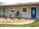 Charming home exterior featuring a blue front door, beautiful plants and an outdoor seating area at 21 Lake Ave, Winter Haven, FL 33880