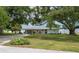Charming home exterior featuring a large front lawn, a vibrant blue front door and a lake view at 21 Lake Ave, Winter Haven, FL 33880