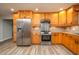 Well-equipped kitchen with stainless steel refrigerator, stove, and light wood cabinets at 21 Lake Ave, Winter Haven, FL 33880