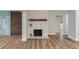Living room featuring luxury vinyl plank flooring and a decorative brick fireplace with a rustic wood beam at 21 Lake Ave, Winter Haven, FL 33880