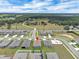 Aerial view pinpoints the property, near a playground, in a community near farmland and a main road at 221 Hilltop Bloom Loop, Haines City, FL 33844