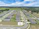 Expansive aerial view pinpoints the property in a large neighborhood near roads, open fields, and amenities at 221 Hilltop Bloom Loop, Haines City, FL 33844