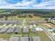 Aerial view pinpoints the property, near a playground, in a community near farmland and a main road at 221 Hilltop Bloom Loop, Haines City, FL 33844