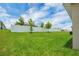 Spacious, well-maintained backyard with a white fence and young trees, offering privacy and a serene outdoor space at 221 Hilltop Bloom Loop, Haines City, FL 33844