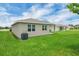 A backyard view shows the home's exterior with a green lawn and covered patio at 221 Hilltop Bloom Loop, Haines City, FL 33844