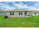 A backyard view shows the home's exterior with a green lawn and covered patio at 221 Hilltop Bloom Loop, Haines City, FL 33844