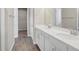 Bathroom with double sink vanity featuring white countertops, light gray walls, and wood-look tile flooring at 221 Hilltop Bloom Loop, Haines City, FL 33844