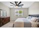 Bright bedroom boasts a window view, dark wooden dresser, and a comfortable queen-size bed at 221 Hilltop Bloom Loop, Haines City, FL 33844