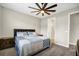 Cozy bedroom featuring a ceiling fan and comfortable queen-size bed with a stylish blue quilt at 221 Hilltop Bloom Loop, Haines City, FL 33844