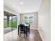 Cozy dining area with natural light, wood-look tile flooring, and a view of the patio at 221 Hilltop Bloom Loop, Haines City, FL 33844