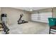 Spacious garage with concrete floors, exercise equipment, and ample storage space at 221 Hilltop Bloom Loop, Haines City, FL 33844