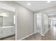 Bright hallway with wood-look flooring, neutral walls, and doorways leading to bathroom and bedroom at 221 Hilltop Bloom Loop, Haines City, FL 33844