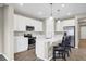 Well-equipped kitchen boasts white cabinetry, stainless steel appliances, quartz countertops, and a breakfast bar at 221 Hilltop Bloom Loop, Haines City, FL 33844