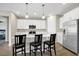 Bright kitchen with white cabinetry, stainless steel appliances, quartz countertops, and a convenient breakfast bar at 221 Hilltop Bloom Loop, Haines City, FL 33844