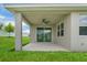 Covered patio provides a comfortable outdoor space with a ceiling fan and view of the backyard at 221 Hilltop Bloom Loop, Haines City, FL 33844