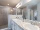 Stylish bathroom with a double vanity, granite countertop, and a modern glass-enclosed shower at 2231 Summerlake Ct, Auburndale, FL 33823