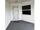 Covered front porch with a storm door, vinyl siding, and a small window at 2235 Grand Cypress Dr # 561, Lakeland, FL 33810