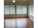 Sunlit room features wood-look flooring and large windows overlooking the yard at 2235 Grand Cypress Dr # 561, Lakeland, FL 33810
