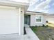 Inviting single-story home with an attached garage, manicured lawn, and a modern green front door at 2517 Sunset Dr, Winter Haven, FL 33881