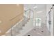 Bright foyer boasts soaring ceilings, a modern staircase with glass railings, and elegant tile flooring at 2736 Sunrise Landing Ln, Lakeland, FL 33812
